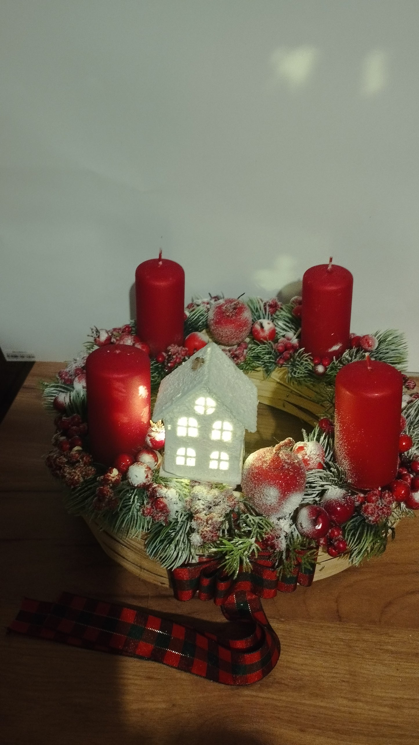 Hagyományos piros adventi  havas bogyókkal világító házikóval