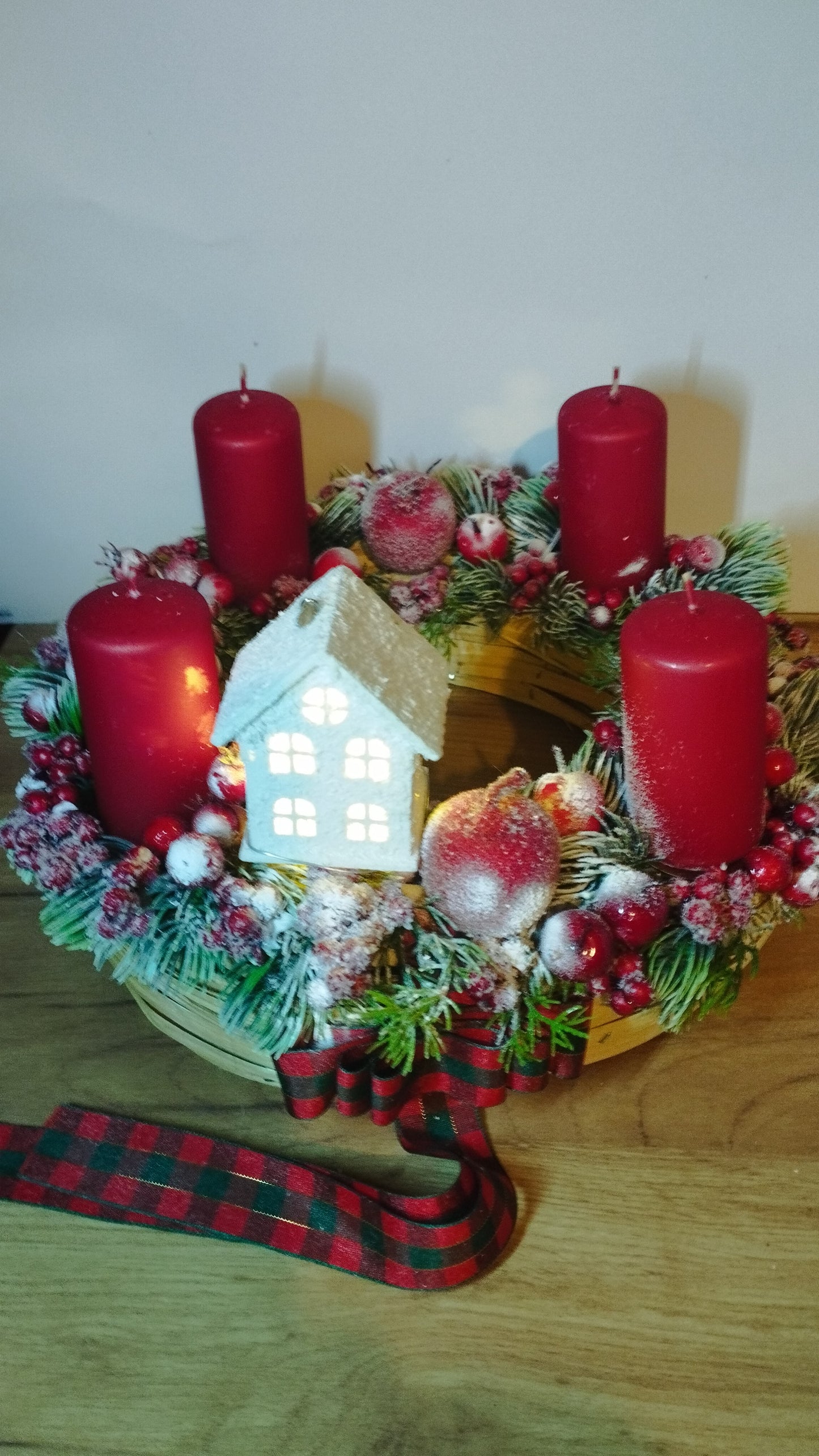 Hagyományos piros adventi  havas bogyókkal világító házikóval