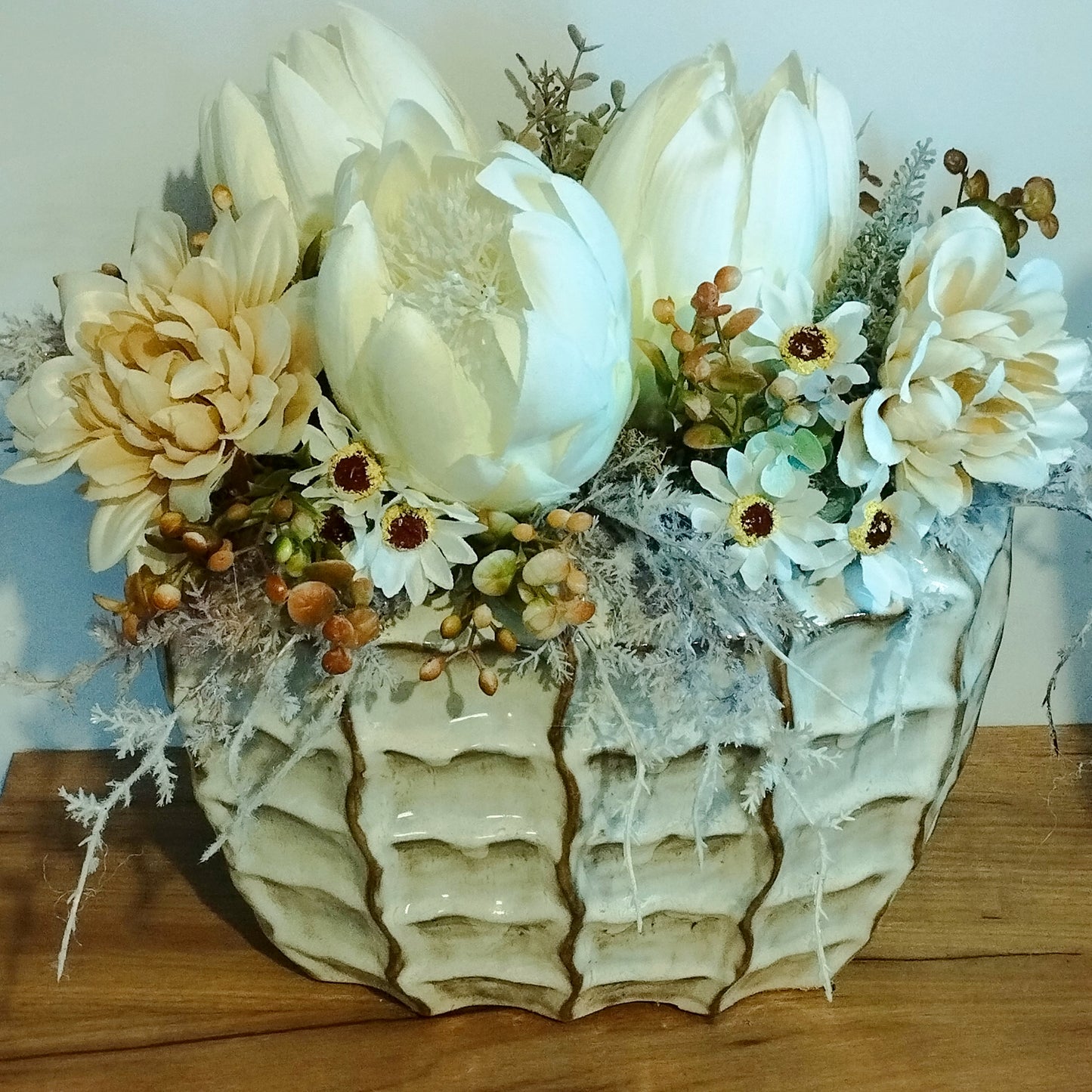 Bézs virágok és fehér  Protea egy impozáns kaspóban