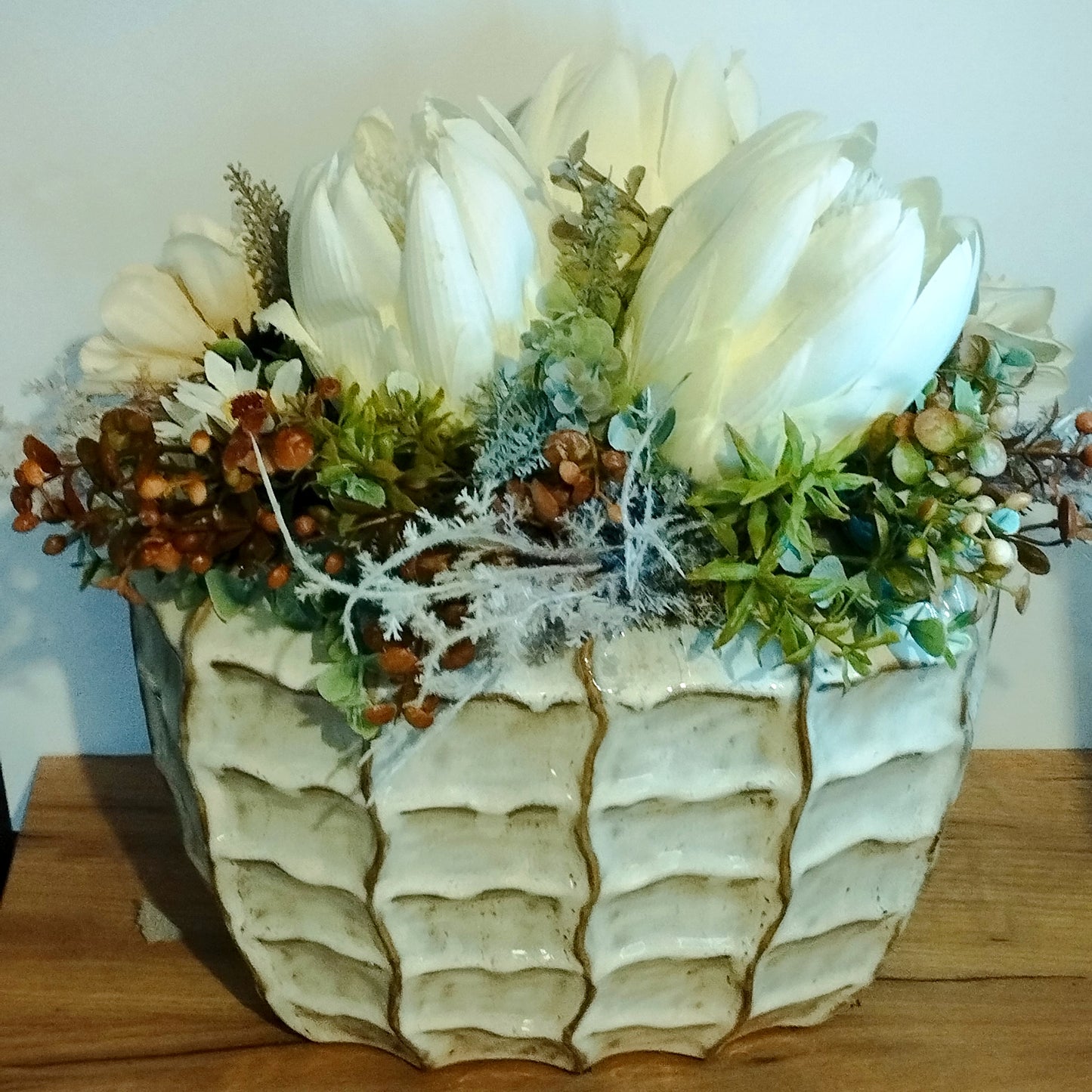 Bézs virágok és fehér  Protea egy impozáns kaspóban